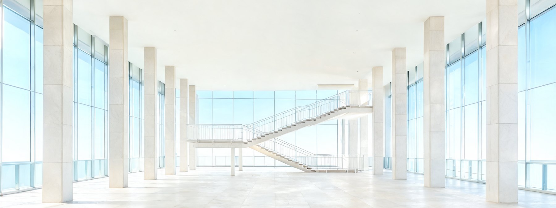 An empty monumental institutional corridor under cold daylight.